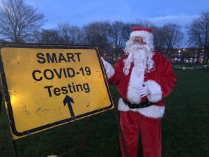 Santa Claus stood next to a smart test centre sign