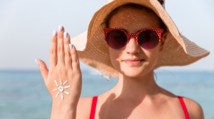 Woman in a sun hat applying sun cream