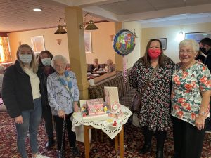 Mary’s granddaughter and great-granddaughter to the left, Mary in the middle with Cllr Marion Atkinson to the right and club organiser Bobby to the far right.
