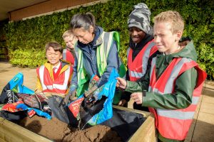 School children and volunteers gardening 