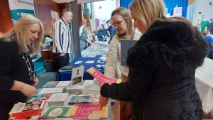 People picking up leaflets from a stall about apprenticeships
